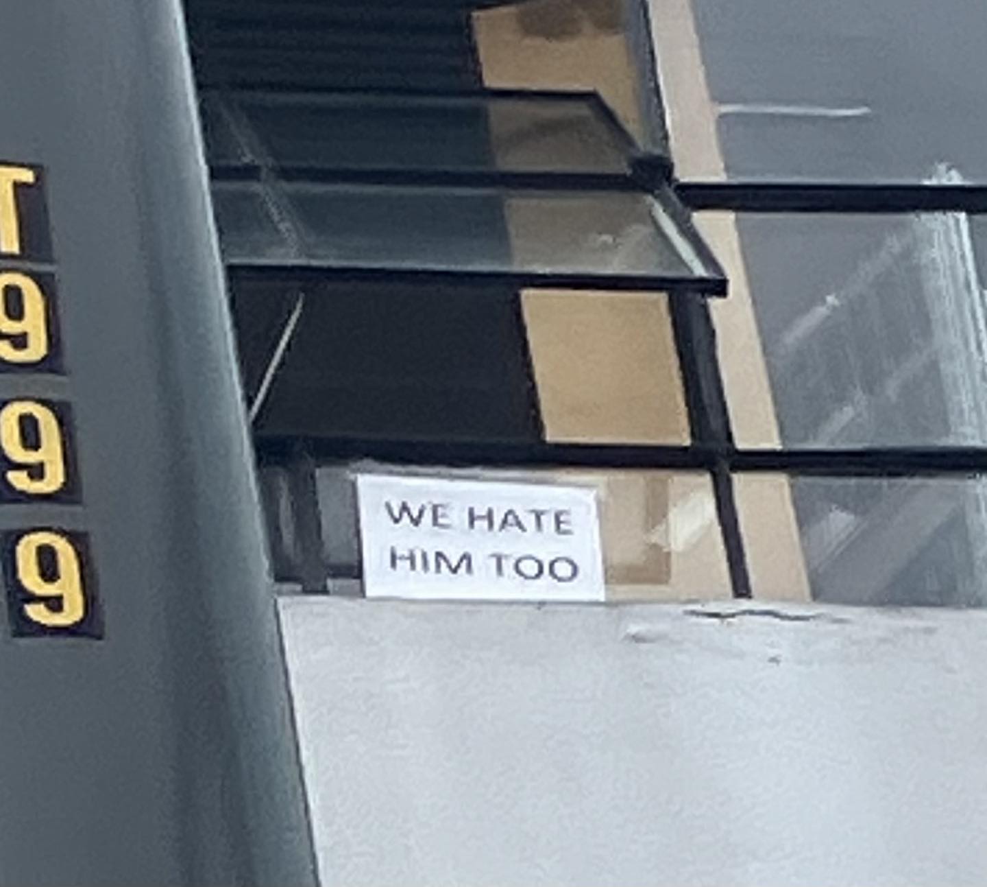 "We Hate him Too" outside a Tesla window